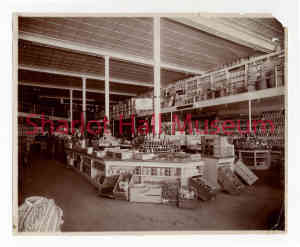 Antique sepia photograph of Bashford-Burmister store interior with counter well-stocked with canned goods